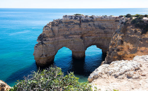 Scenic view of rock formation in sea against sky