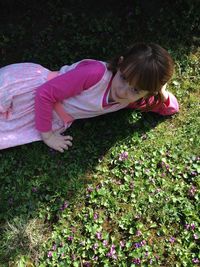 High angle portrait of girl lying on field at park