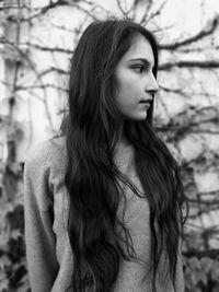 Young woman with long hair against trees