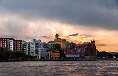 Buildings in city against cloudy sky