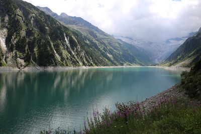 Scenic view of lake by mountains against sky