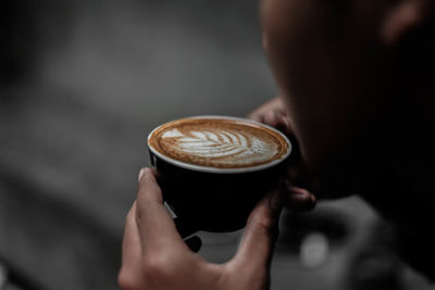 Cropped image of woman holding coffee cup