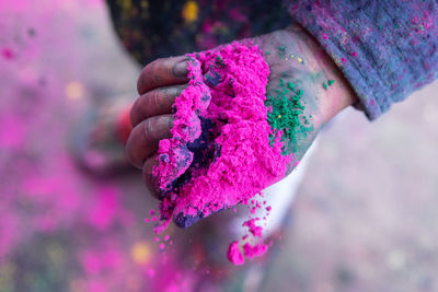 Close-up of hand holding pink flower