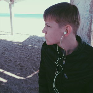 Portrait of young man looking away outdoors