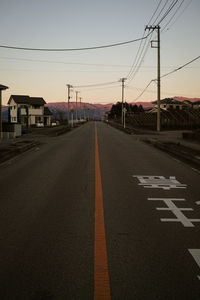 Road leading towards city against sky