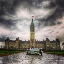 View of clock tower in river against cloudy sky