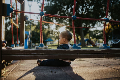 Rear view of boy sitting outdoors