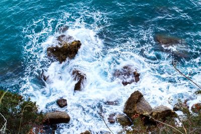 High angle view of waves splashing on rocks