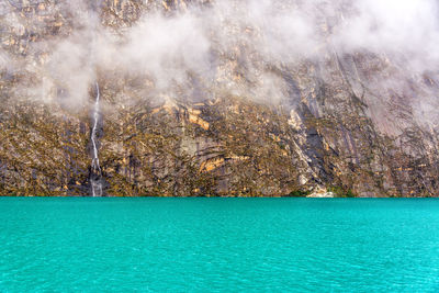 Idyllic view of llanganuco lake against rock formations