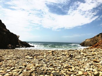 Rocks on beach against sky