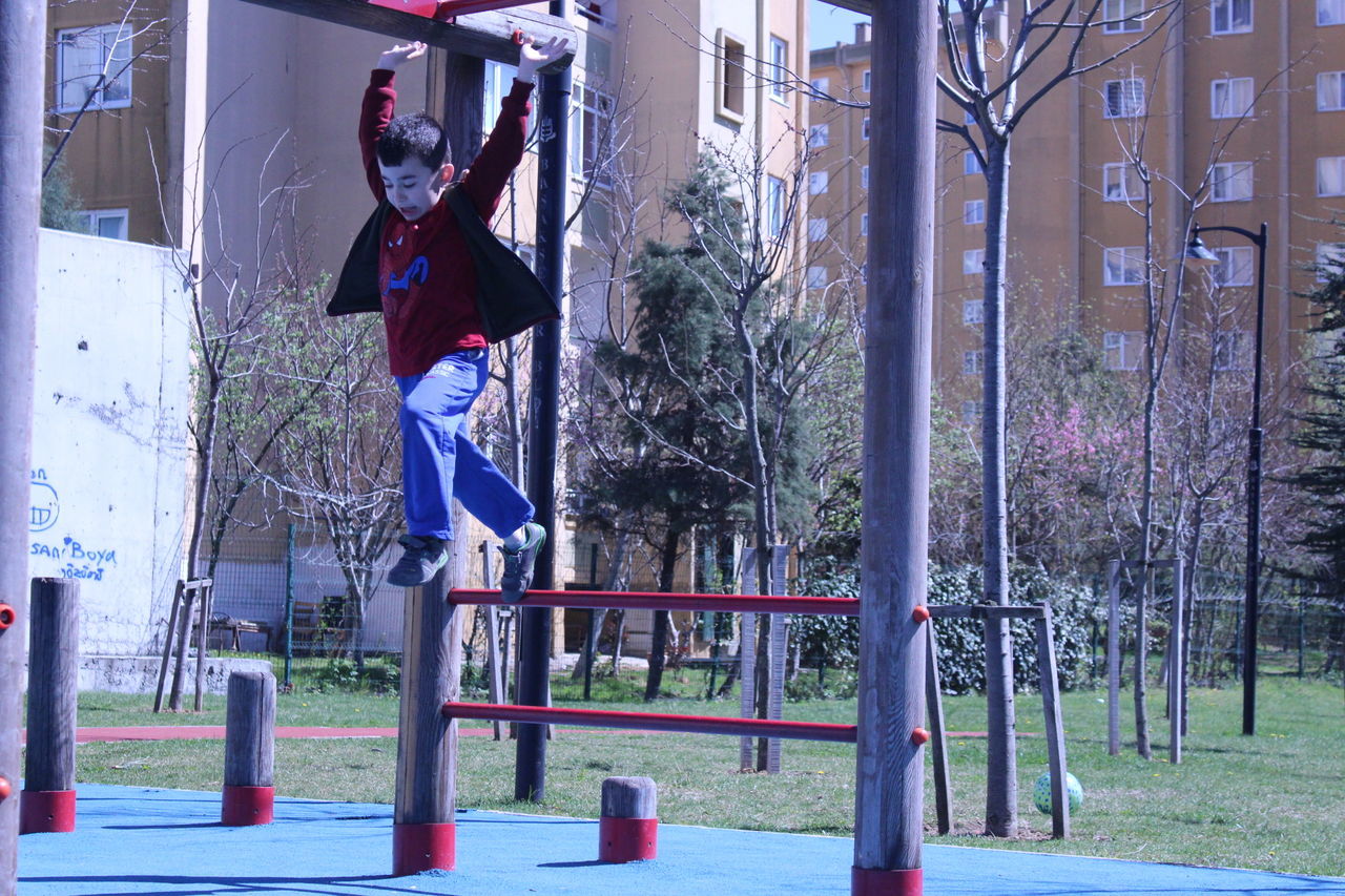 MAN JUMPING IN CITY AGAINST TREES