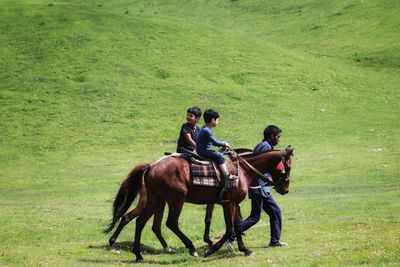 People riding horse on field