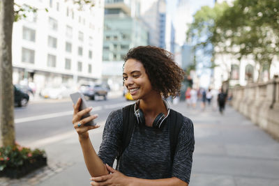 Young woman smiling while standing in city