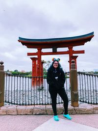 Full length portrait of woman standing against sky