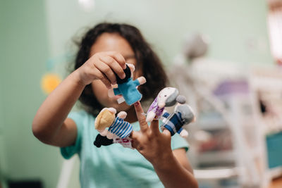 Close-up of cute girl holding toy at home