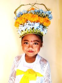Portrait of balinese little girl standing against wall, before religion ceremony 