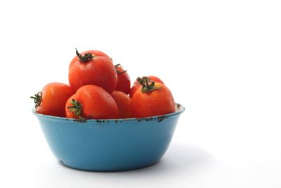 Close-up of tomatoes in bowl against white background