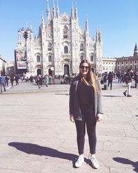 Full length portrait of happy woman standing against duomo di milano