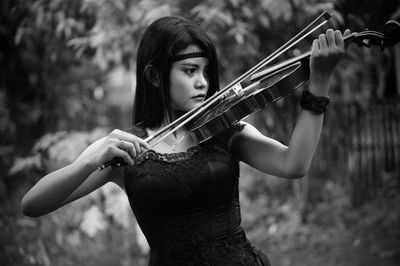 Young woman playing violin the outdoors