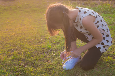 Full length of woman sitting on field