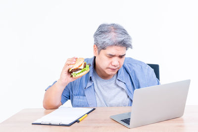 Young man using mobile phone while sitting on table