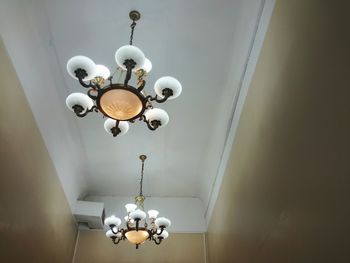 Low angle view of illuminated lamp hanging on ceiling