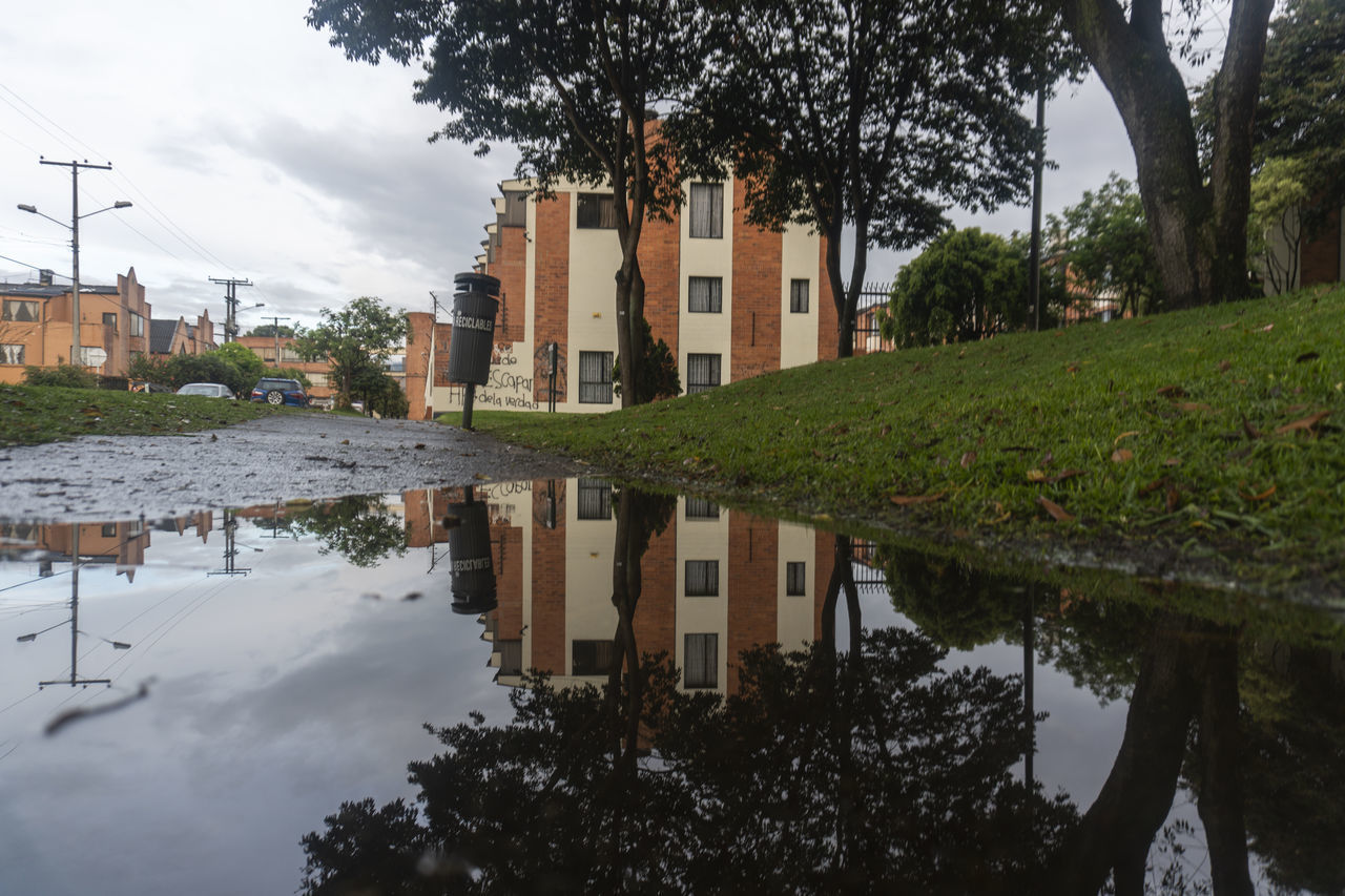 REFLECTION OF BUILDINGS IN PUDDLE ON LAKE