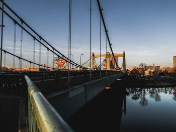 Bridge over river against sky in city