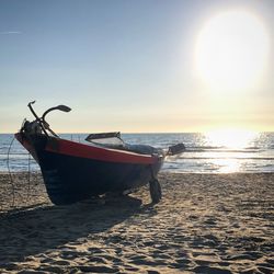 Boat in sea against sky during sunset