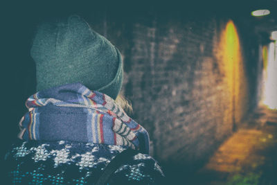 Rear view of person walking in alley