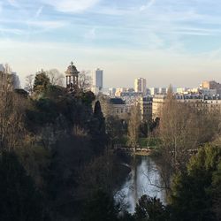 High angle view of buildings by river against sky