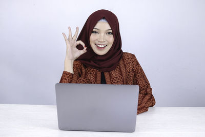 Portrait of a smiling young woman using phone