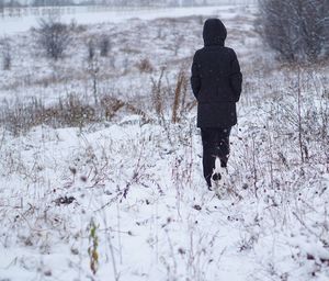 Man standing on snow covered flowers