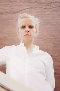 Portrait of woman standing against wall