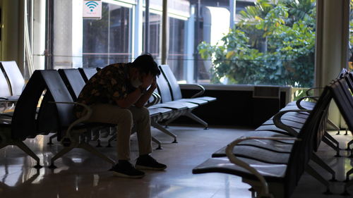 Woman sitting on table by window