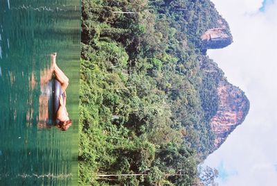 Full length of shirtless man in sea against mountains