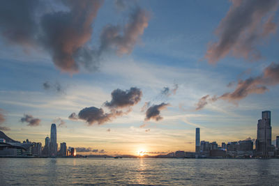 Scenic view of sea and buildings against sky during sunset