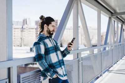 Low angle view of woman looking through mobile phone