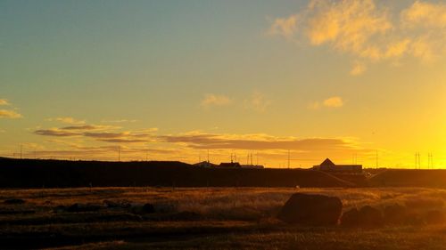 Scenic view of silhouette field against sky during sunset