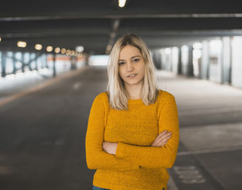 Portrait of smiling young woman standing in underground parking lot