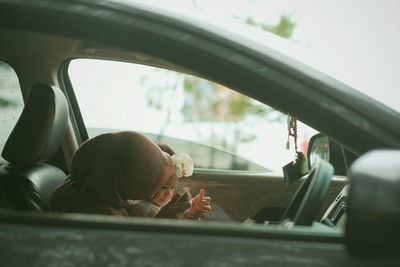 Portrait of boy seen through car window