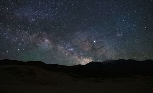 Scenic view of mountains against sky at night