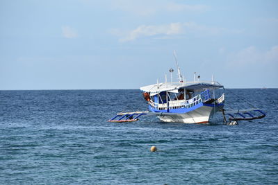 Fishing boat in sea against sky