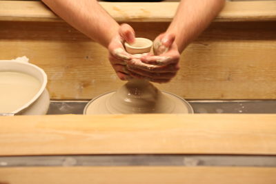 Cropped hands of man making pottery