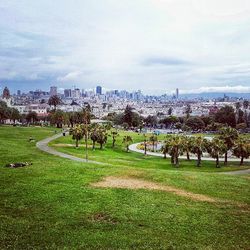 View of cityscape against cloudy sky