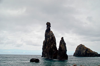 Rock formations in sea against sky