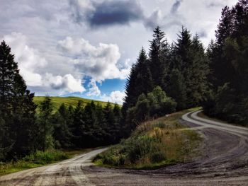 Country road against cloudy sky