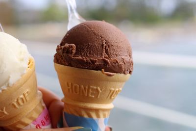 Cropped hand of woman holding ice cream cones