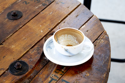 Dirty empty coffee mug cups containing coffee on wooden table in banquet hotel buffet business.