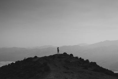 Man standing on mountain against sky